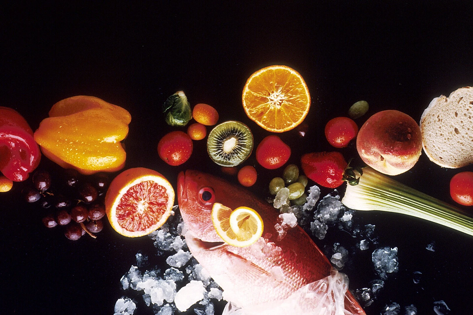 Assorted vegetables, fruit, fish and bread arranged as healthy foods